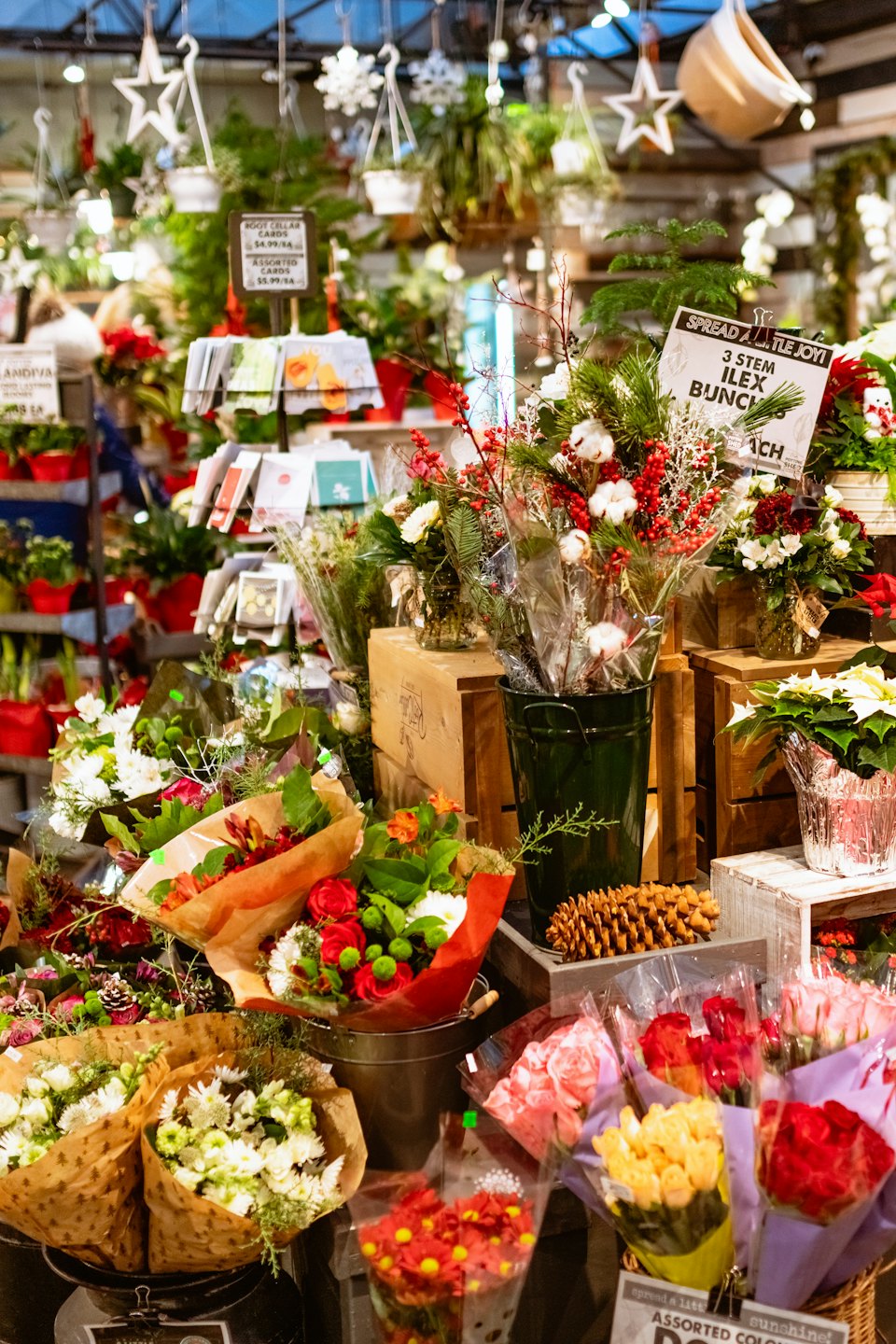 A retail display of holiday flower arrangements and gift cards.